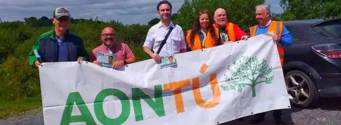 Carl is the guy in the white top in middle standing behind the banner.